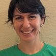 Emma Meyers, smiling, with short dark hair and a green T-shirt.