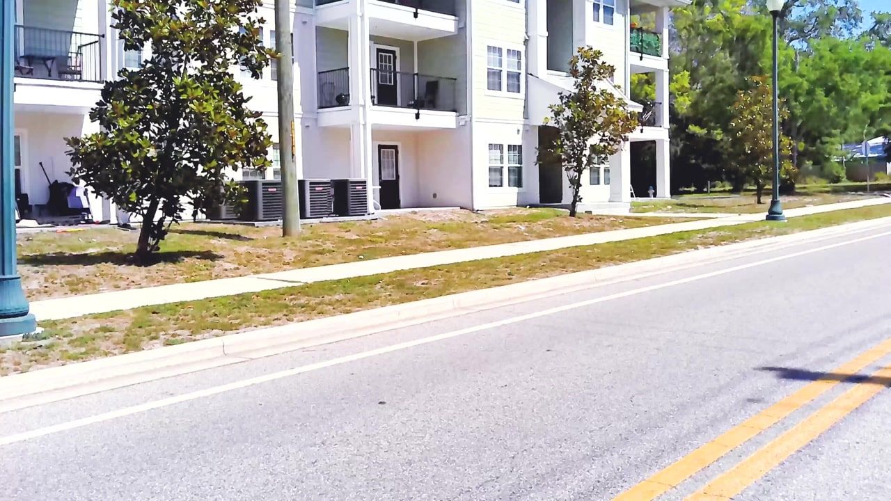 A street of white apartment buildings and young magnolia trees in Newtown, Sarasota.